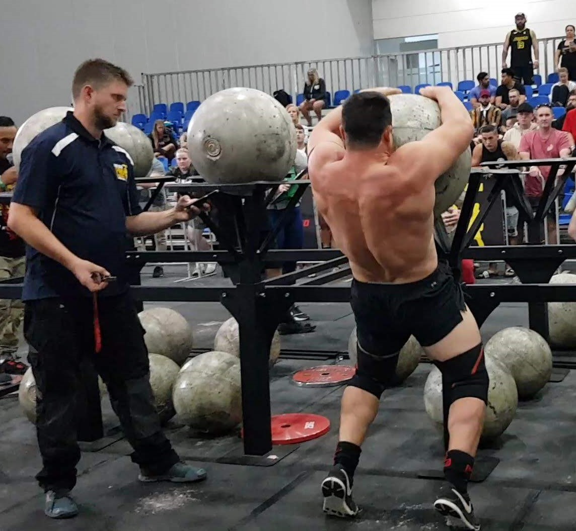 Strongman athlete loading an Atlas stone