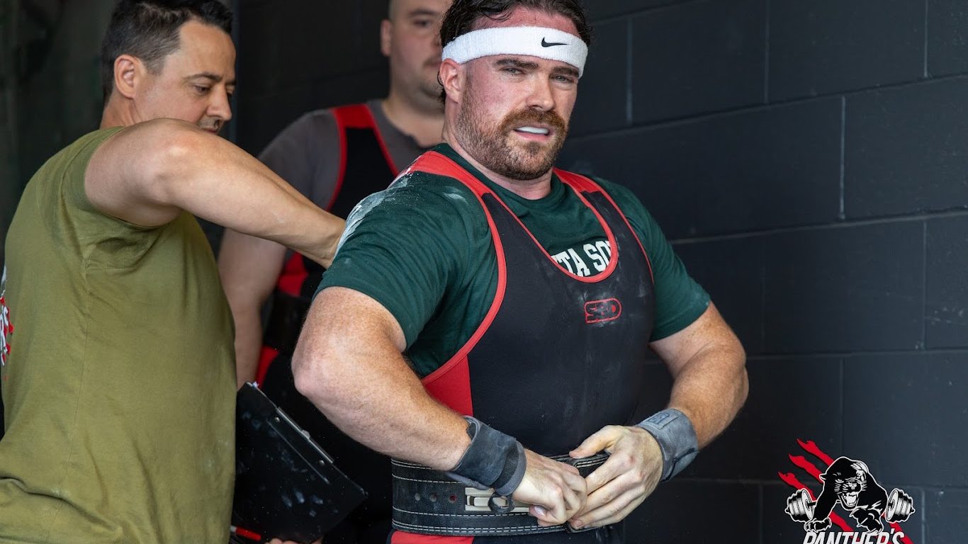 Panthers Powerlifting coach Colin Webb preparing a lifter for competition.